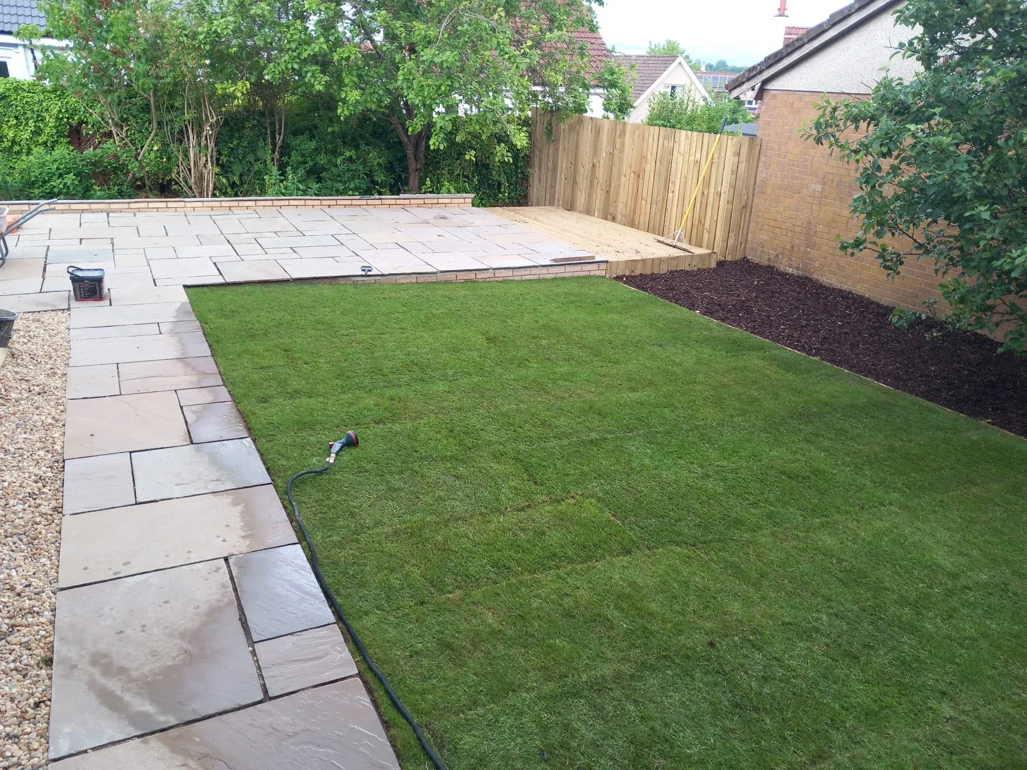 New lawn laid alongside a sandstone patio in Stirling