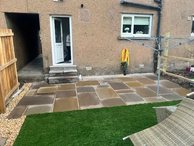Sandstone patio with artificial grass installed in Stirling
