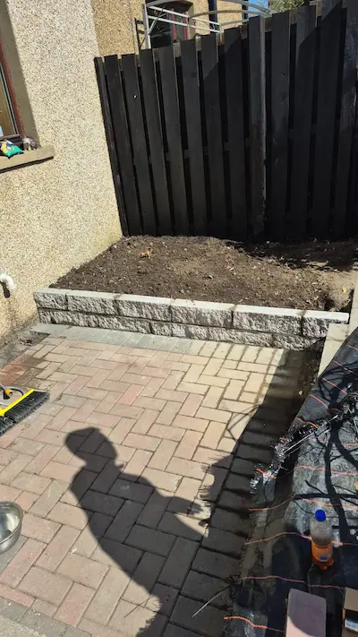 Retaining wall being installed in a garden in Stirling